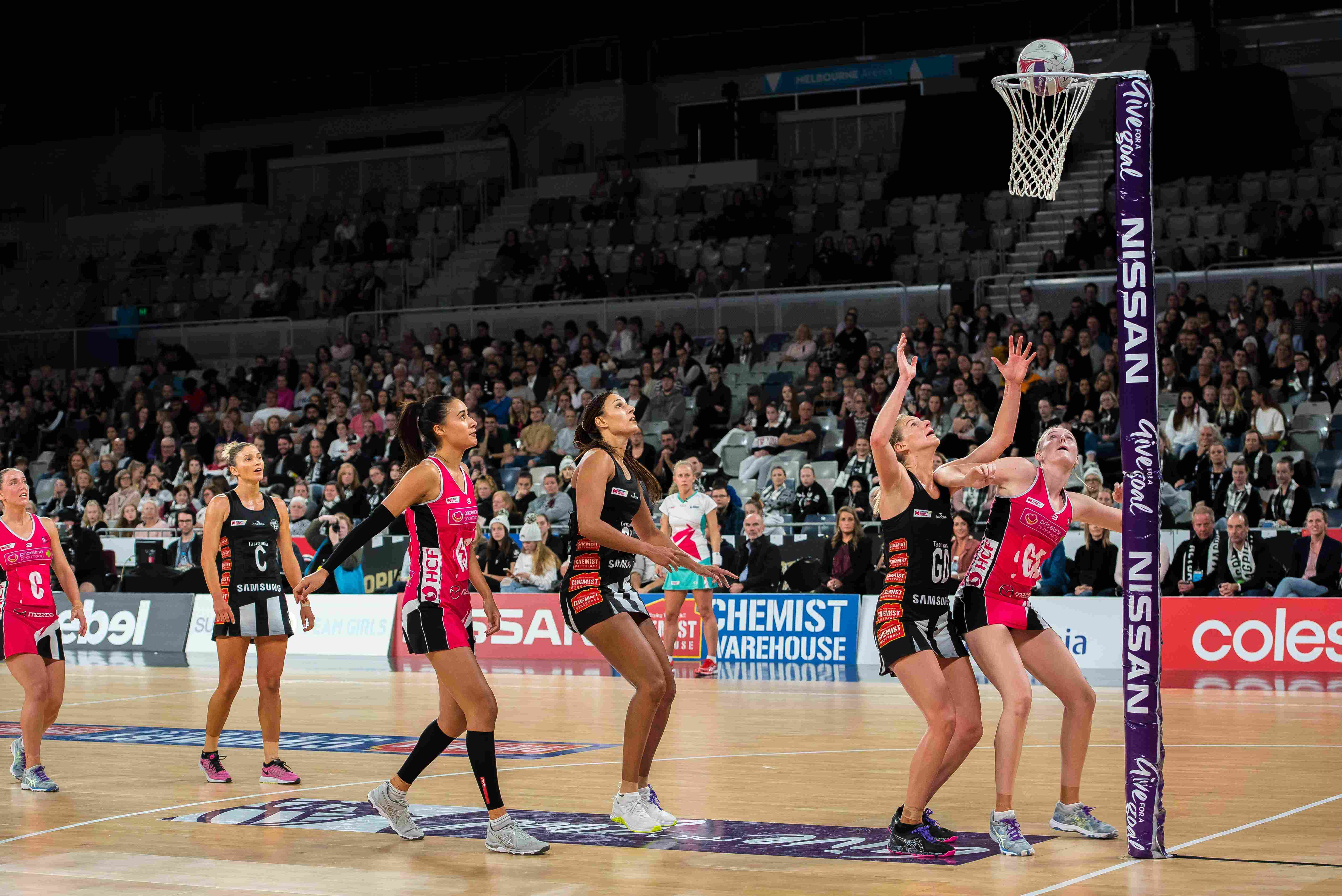 action shot of netball player scoring